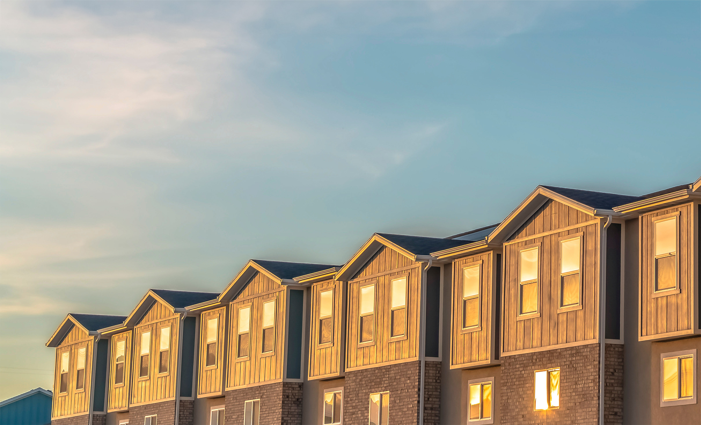 Panorama Exterior of single-family rentals with wood and brick wall sections and sliding windows