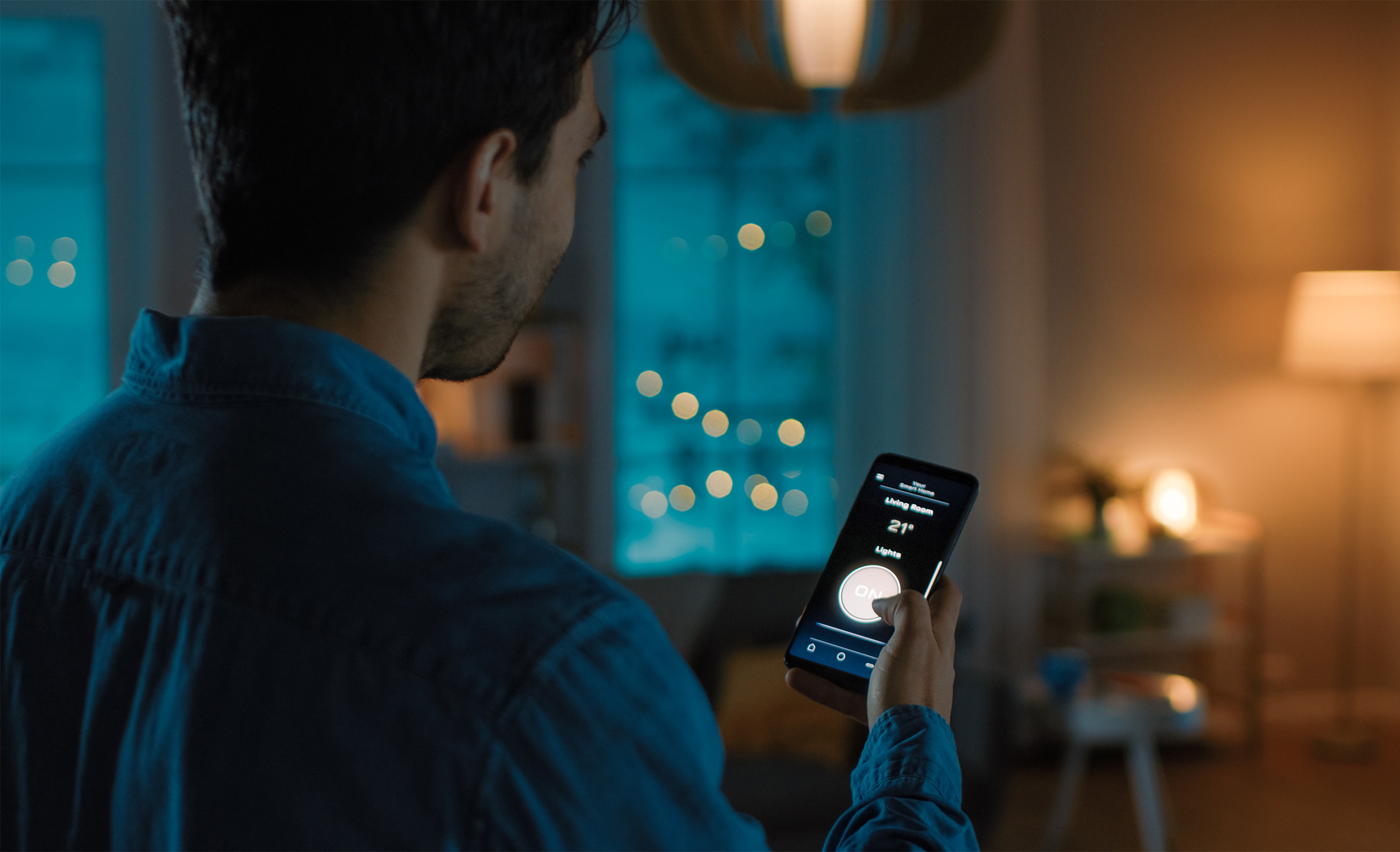 Man holding phone controlling smart tech apartment devices