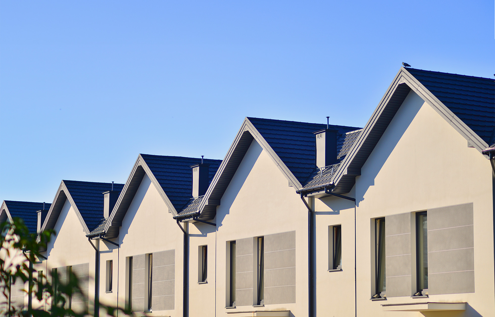 Suburban neighborhood condominium complex geometric family houses against blue sky