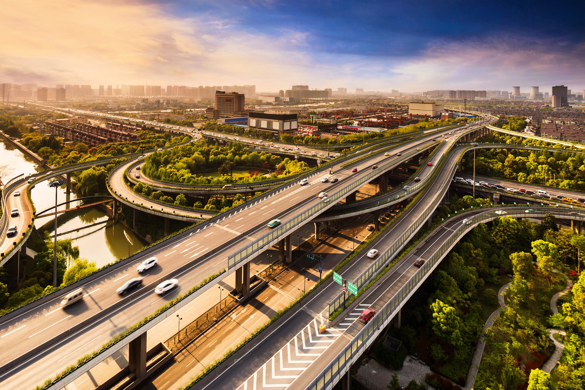 Elevated overpass with skyline of modern city during sunset.