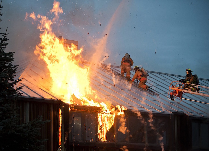 Firefighters on the roof of a burning building in Alaska