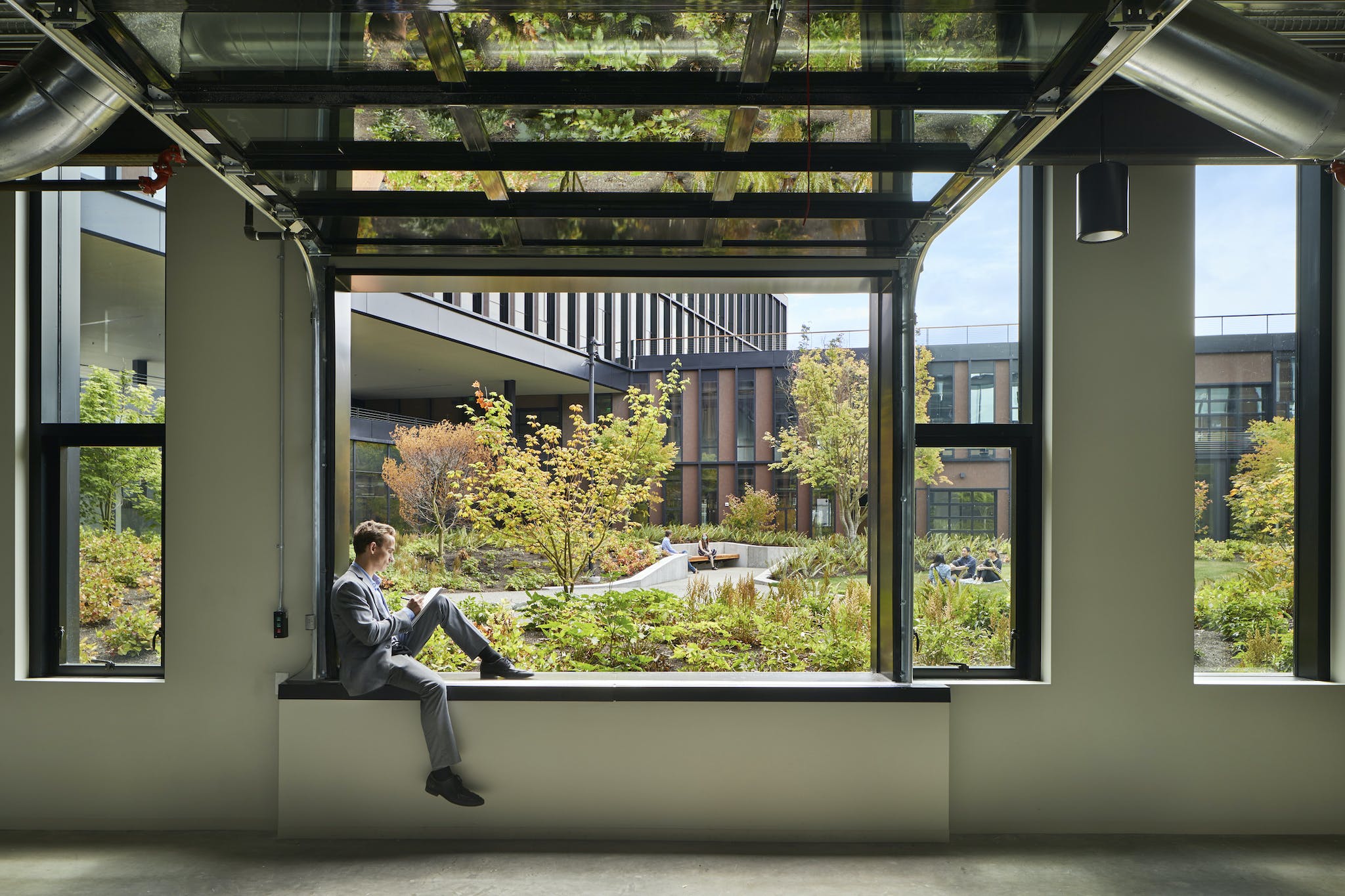 Man writing on notepad in front of big window