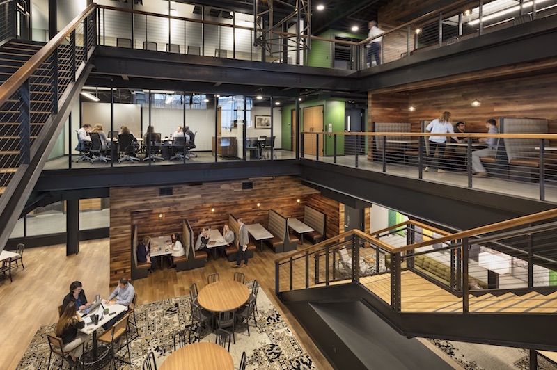 A glass-walled conference room overlooks the atrium.