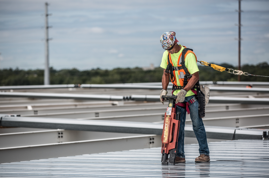 A Barton Malow construction worker installs a metal roof deck.