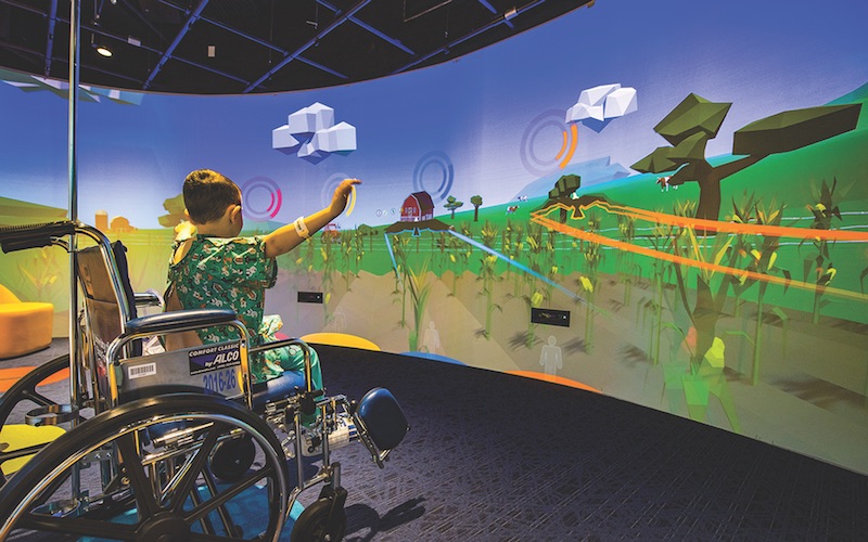 A child uses the Nick's Theater in the Gerdin Family lobby at the Stead Family Children's Hospital