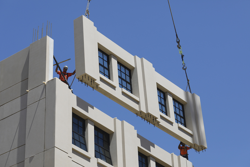 An exterior wall panel, manufactured by Clark Pacific, is positioned into place. Image: Clark Pacific