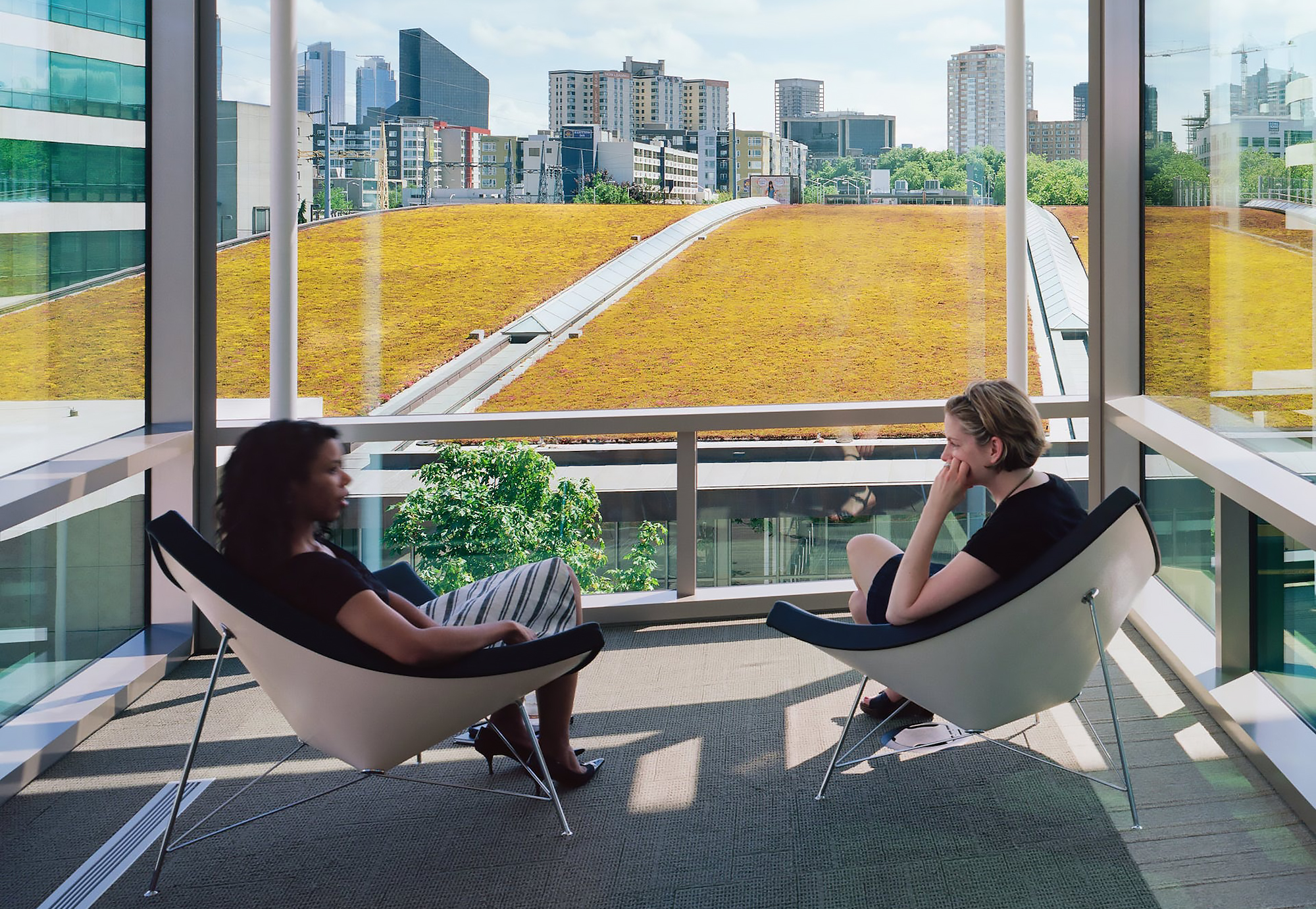 Two people sitting in comfortable chairs in front of window