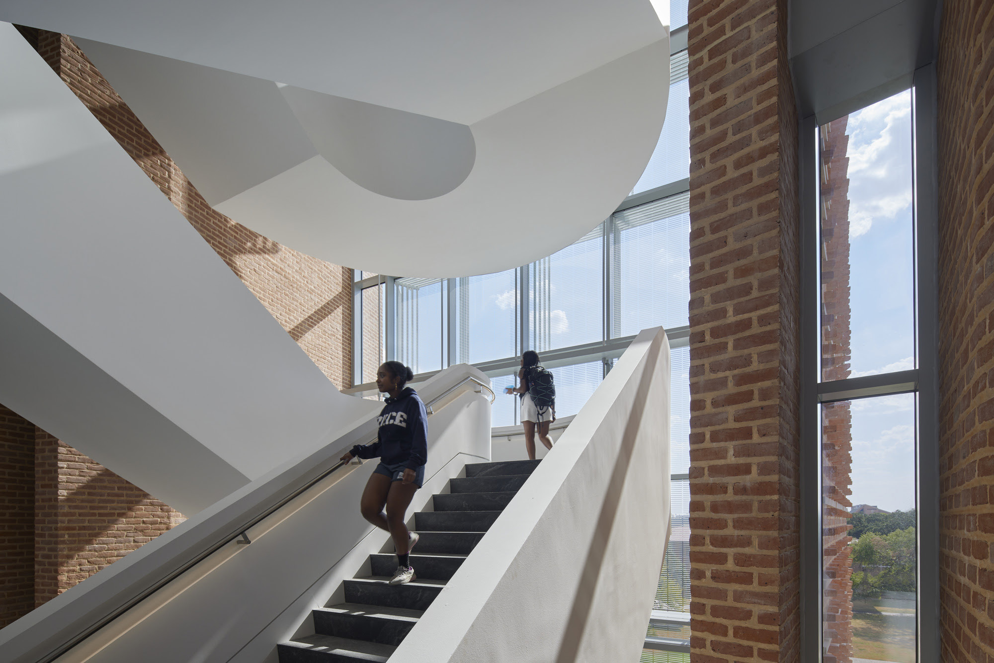 fritted glass wall frame a cantilevered sculptural stair.