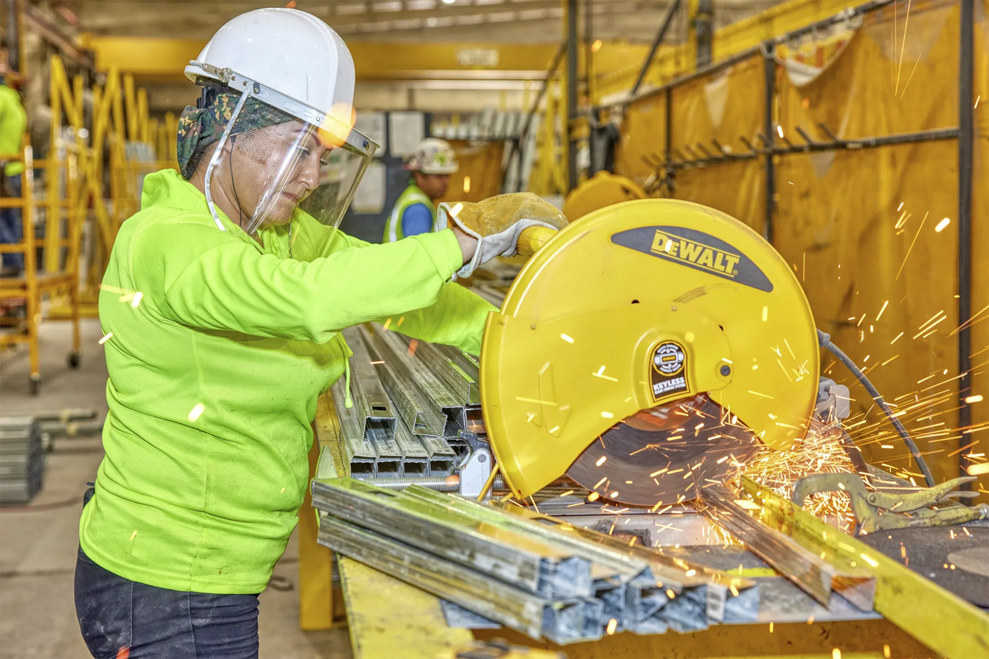 Construction worker using DeWALT saw to cut metal material