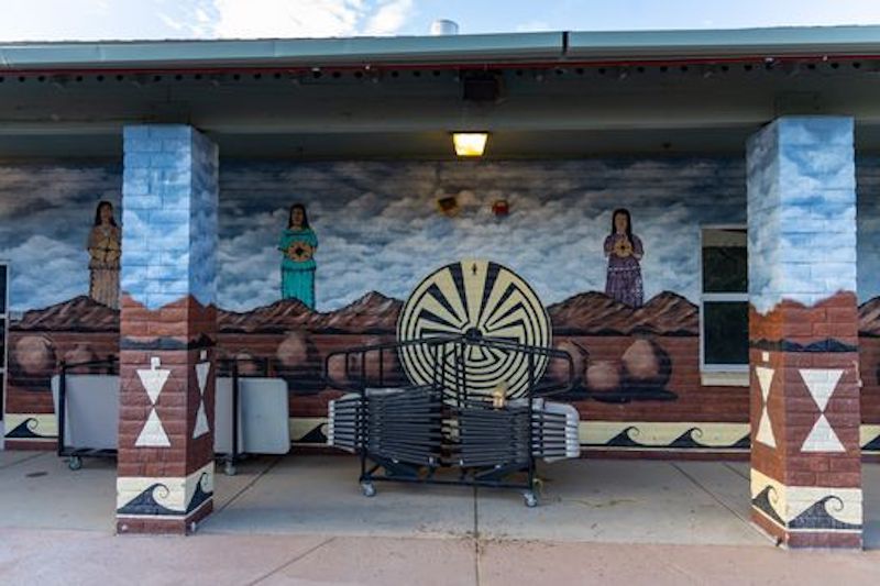 Exterior wall depicts crop harvesting, desert landscapes, and the petroglyphic symbol of the Man in the Maze, or Se:he.