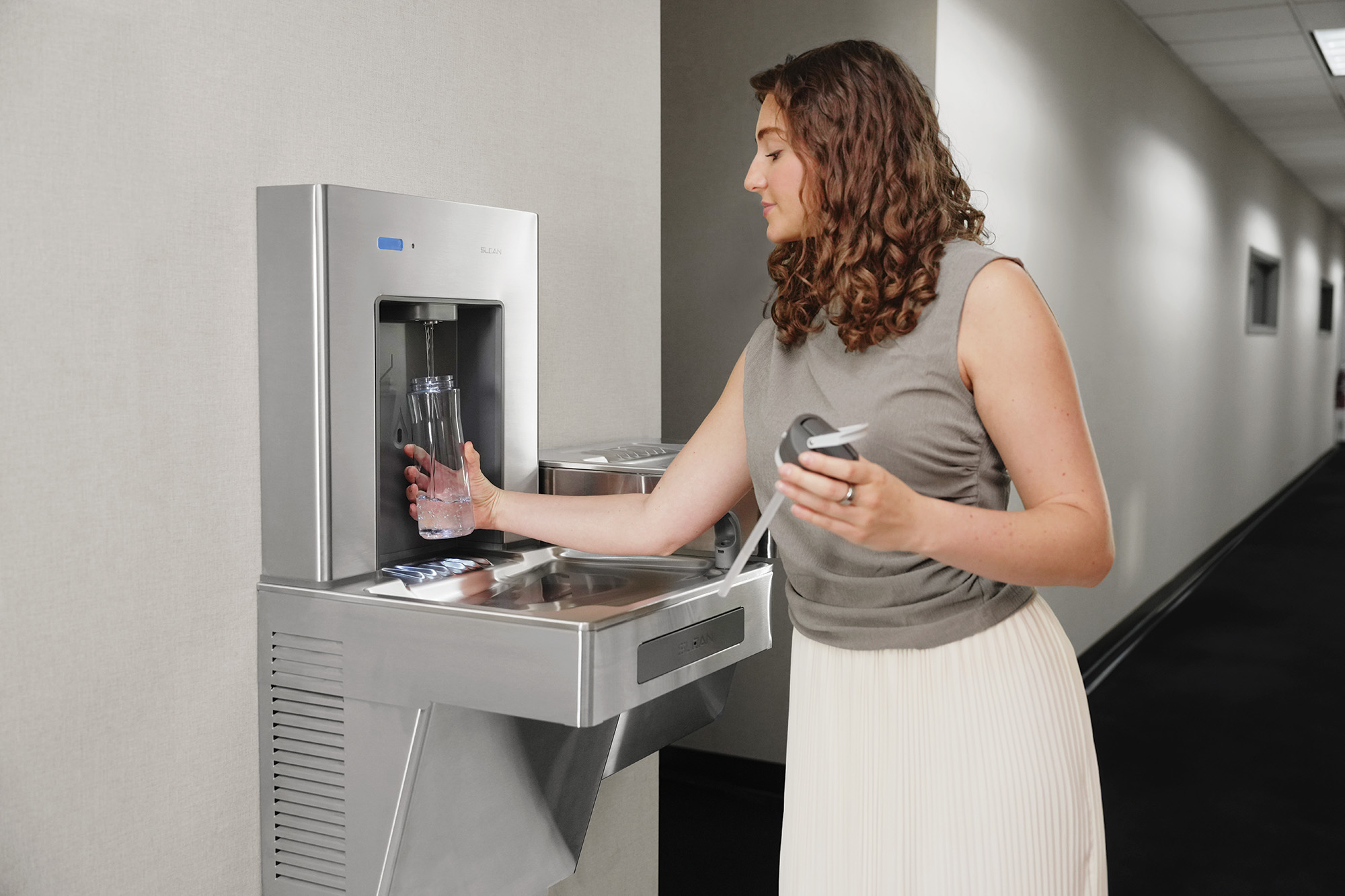 Woman filling up water bottle at DropSpot filling station