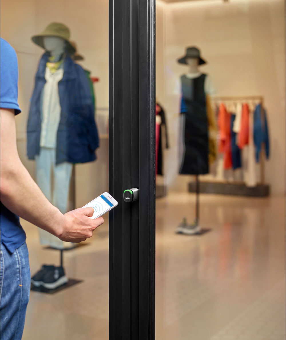 Man using wireless key access to enter a retail store