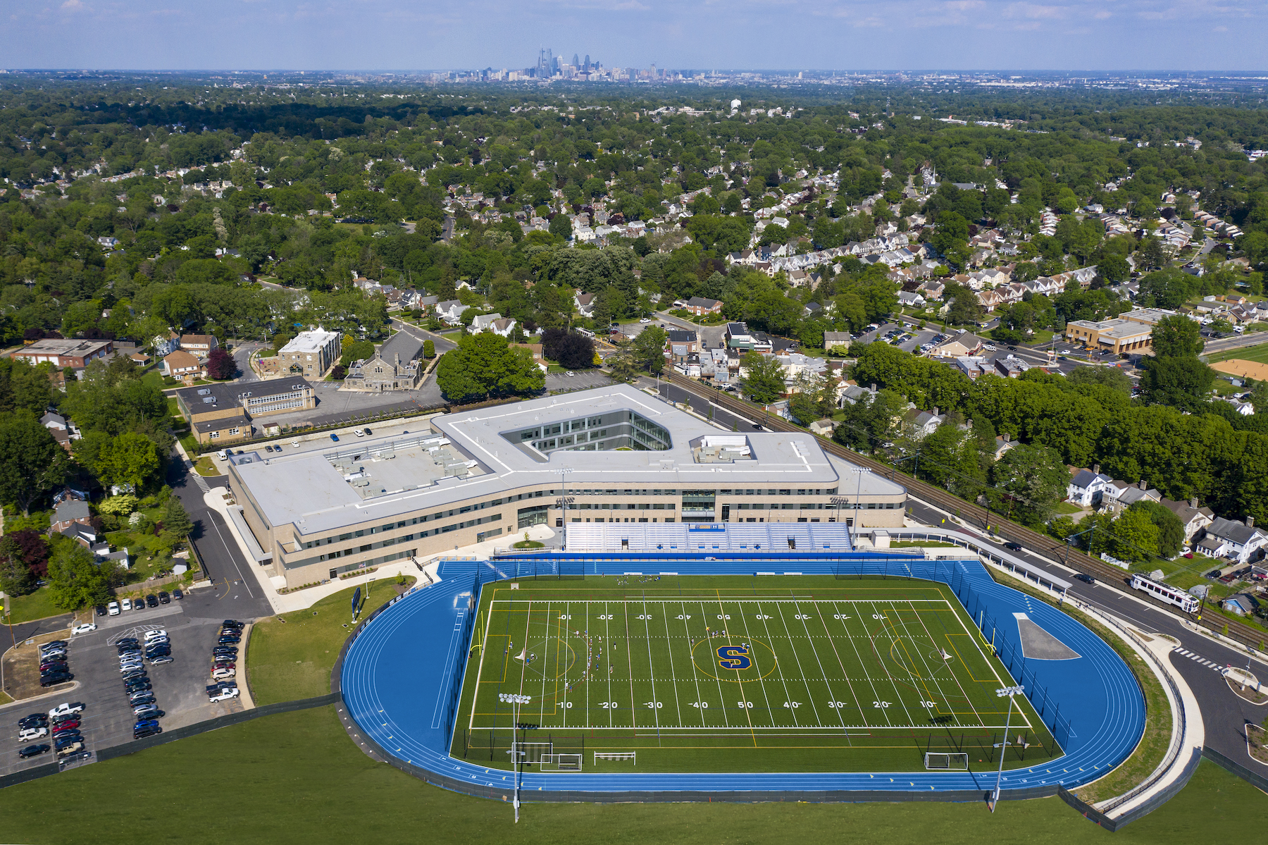 The school's playing fields are positioned as extensions of nearby parks.