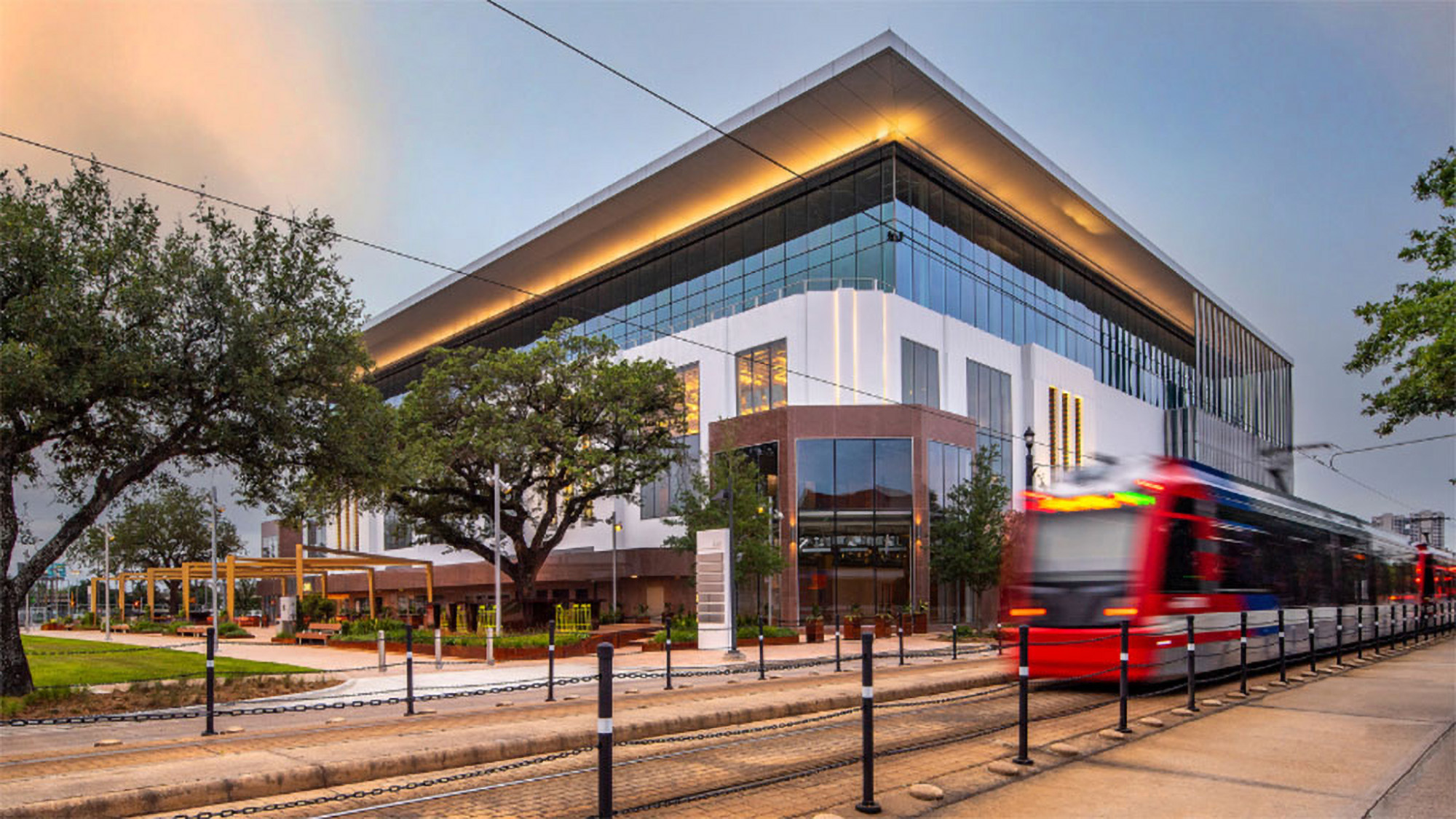 A train on the railway tracks in front of adaptive reuse building