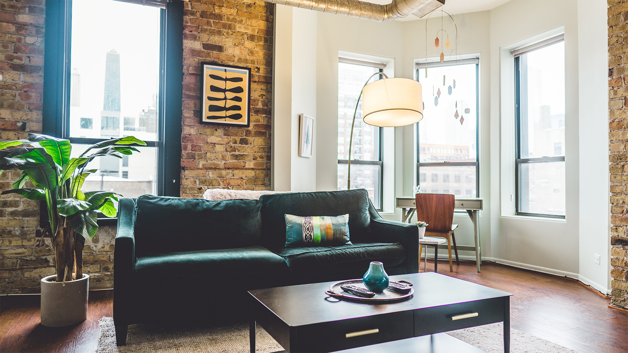 Green 2-seat Sofa in brick apartment