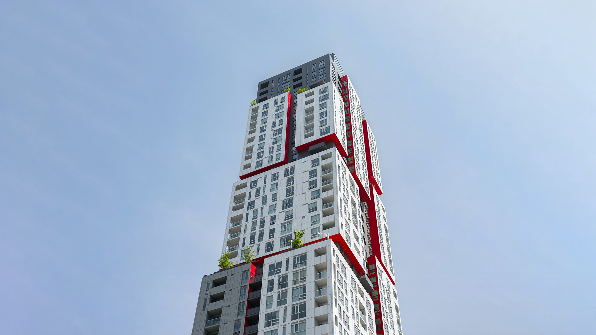 Tall modern apartment complex with blue sky