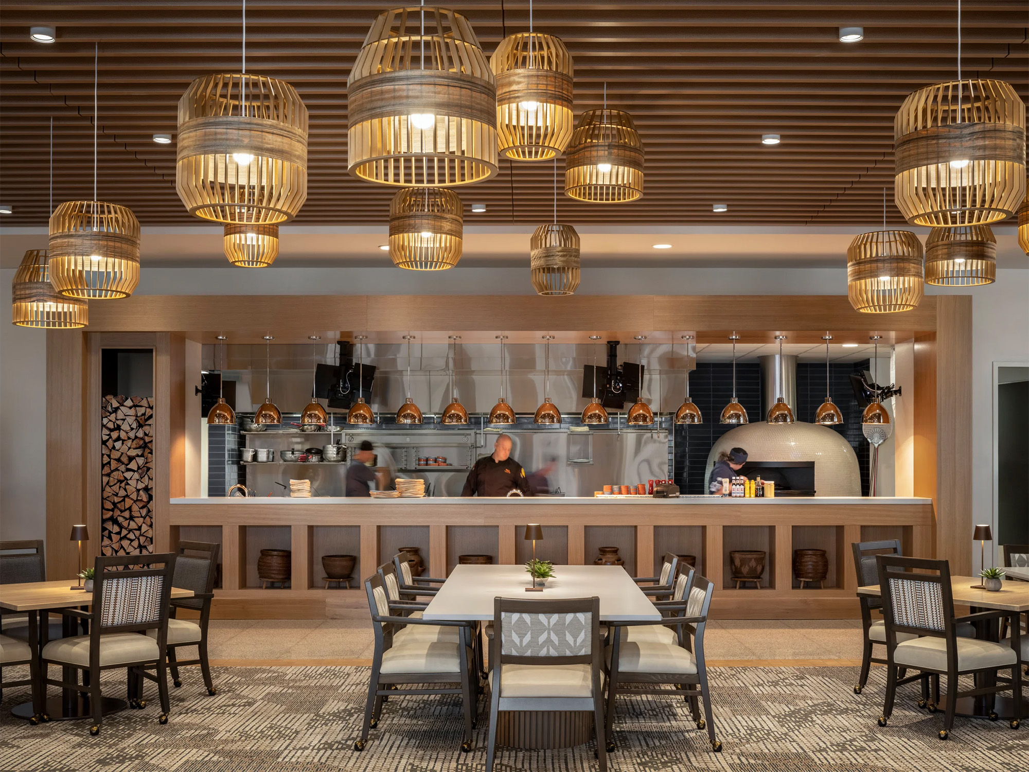 The Indigo Dining Room at Inspirata Pointe at Royal Oaks in Sun City, Arizona, a senior living community, features a large window into the kitchen