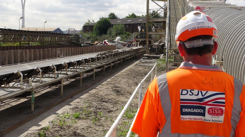 A worker in safety gear looks out over a work site