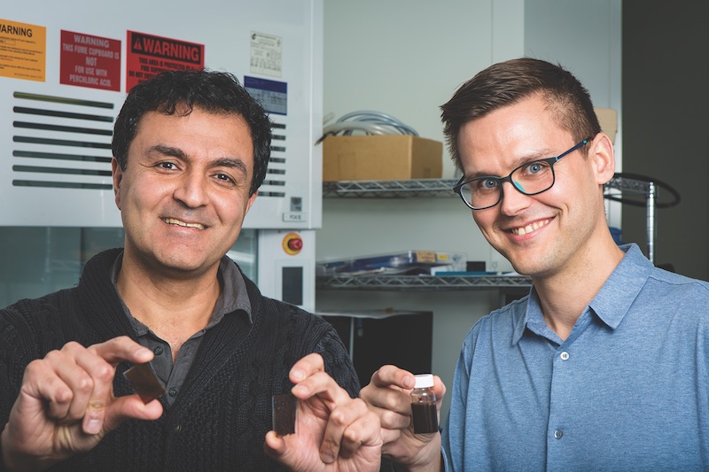 Researchers hold up a jar of the solar paint