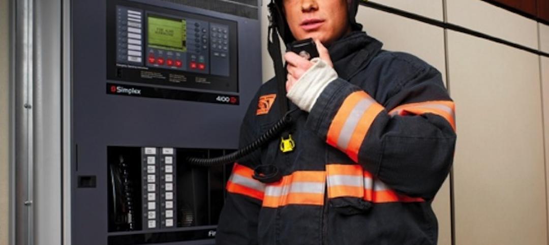 A firefighter uses the voice capabilities of a fire alarm panel (in this case, a