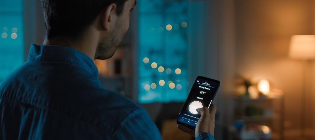 Man holding phone controlling smart tech apartment devices