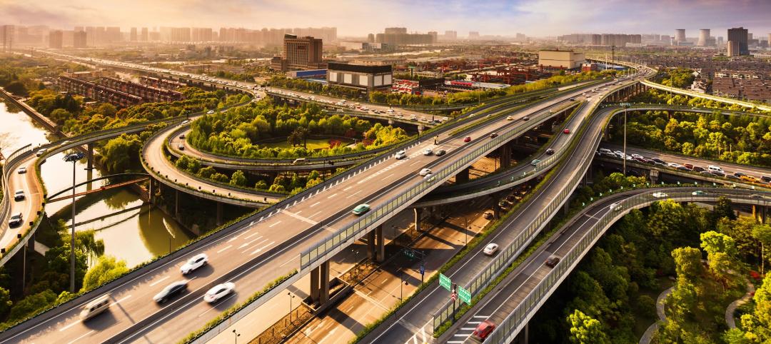 Elevated overpass with skyline of modern city during sunset.