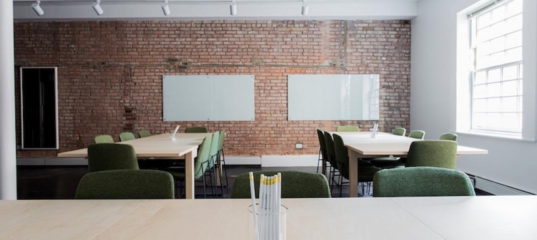 A classroom with large tables and a brick wall