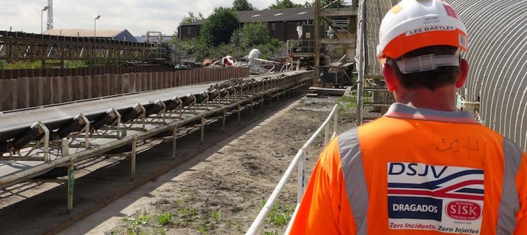 A worker in safety gear looks out over a work site